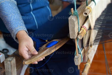 Asian female weavers weaving traditional patterns with hand weaving