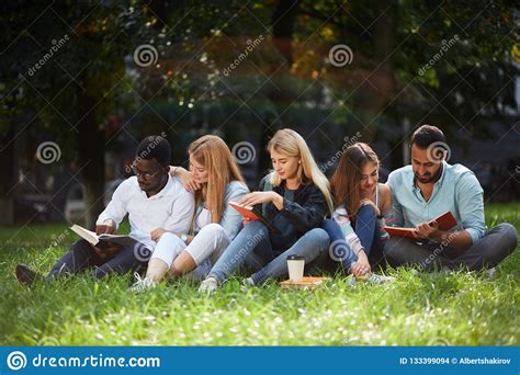 Mixed Race Group Of Students Sitting Together On Green