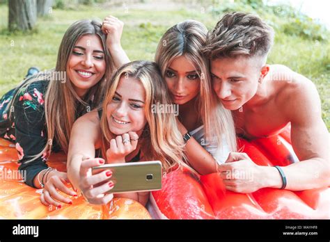 Group Of Millennial Friends Taking A Selfie Outdoors Lying In The Grass