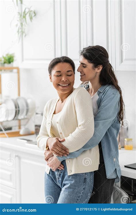 Cheerful Lesbian Woman Hugging Multiracial Girlfriend Stock Image Image Of Apartment Carefree