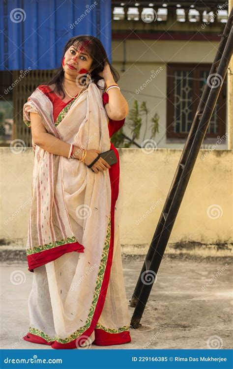 Beautiful Indian Female Model In Traditional Bengali Saree Looking Straight Happily With Slight