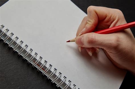 Main Qui écrit Sur Un Cahier Avec Un Crayon Photo Premium