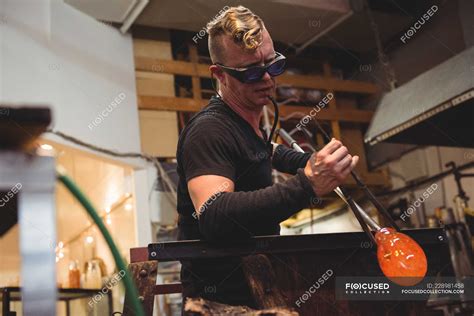 Glassblower Shaping Molten Glass On Marver Table At Glassblowing Factory — Craft Artwork