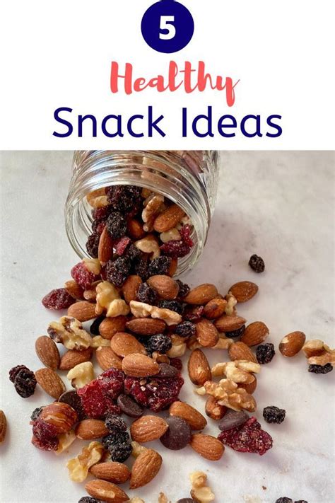 A Jar Filled With Nuts And Cranberries On Top Of A Table