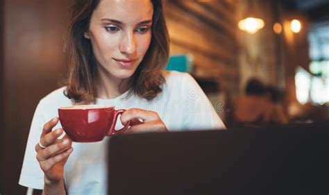 Female Manager Holding In Hands Cup Of Coffee Looking Screen Laptop In