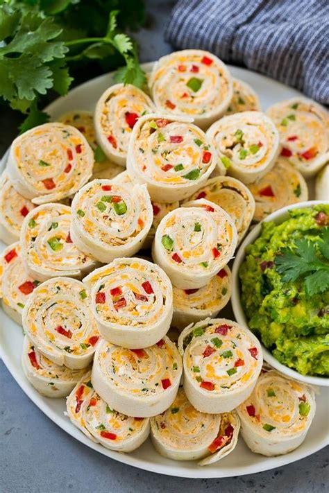 A Plate Full Of Taco Pinwheels With Guacamole On The Side