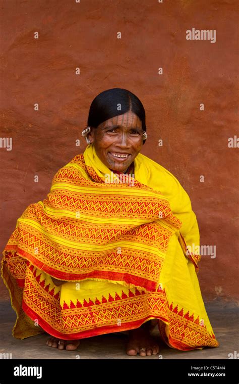A Tribal Woman From India Sitting In A Bright Yellow Sari Stock Photo