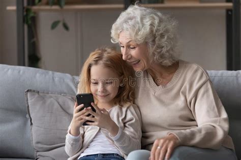 Overjoyed Mature Woman With Little Granddaughter Using Phone Together Stock Image Image Of