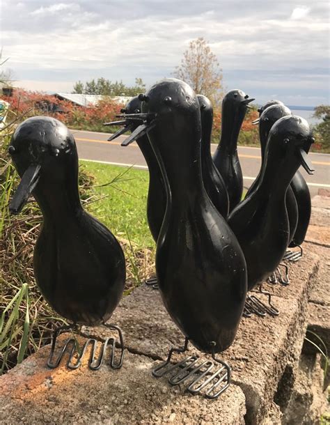 Three Black Birds Sitting On Top Of A Rock