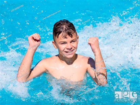 Happy Teen Boy Jumping In The Swimming Pool At Aquapark Stock Photo