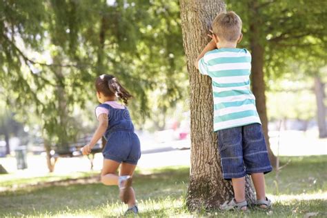 Two Children Playing Hide And Seek In Park Stock Photo Image 54968713