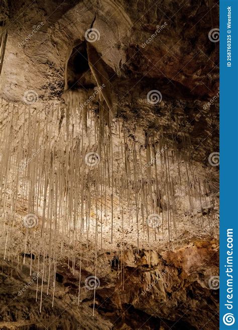 Vertical Shot Of The Inside Of A Cave With Stalactites Hanging From The