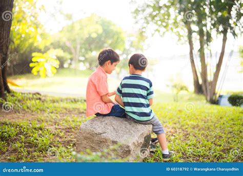 Little Sibling Boy Sitting Together In The Park Outdoor Stock Photo
