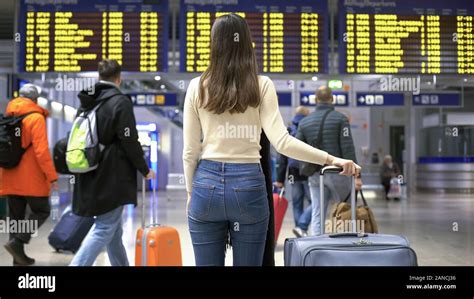 Girl Looking At Flight Arrive And Departure Board Waiting For Check In