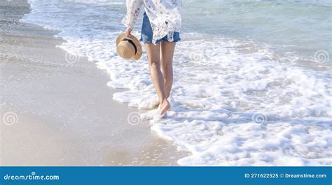 Back View Of Woman S Legs Walking On Sandy Beach Near Turquoise Colored