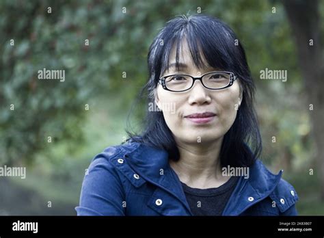 A Pretty Middle Age Korean Woman With A Pleasant Smile In A Park In