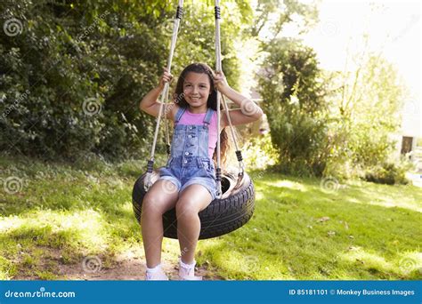 Portrait Of Young Girl Playing On Tire Swing In Garden Stock Image Image Of England Female