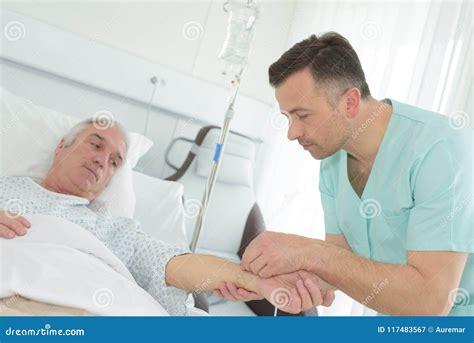Male Nurse Putting Intravenous Drip Into Patients Arm Stock Image