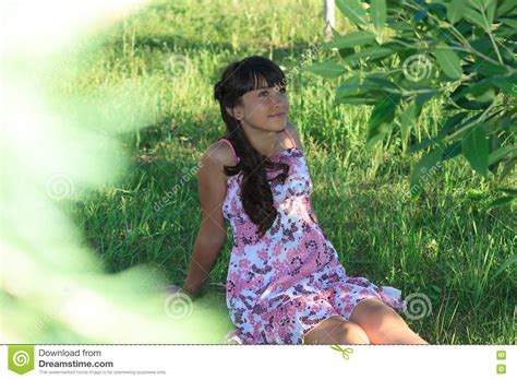 Красивый девочка подросток в розовом платье с длинными волосами в зеленом парке лета Стоковое
