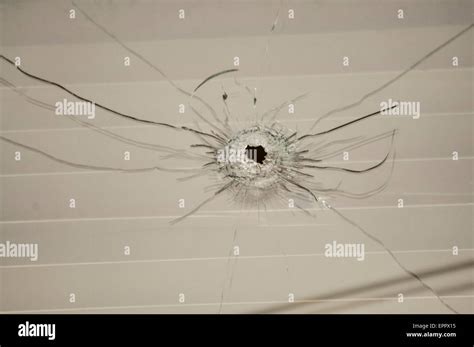 Bullet Hole Left In A Window After A Gun Attack On A House Stock Photo