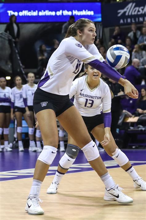 Two Women Playing Volleyball In Front Of An Audience