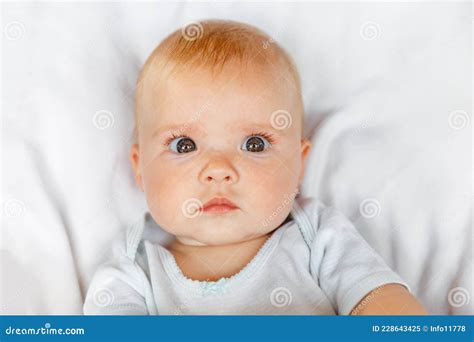 Cute Little Newborn Girl With Funny Face Looking At Camera On White