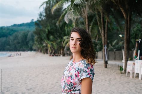 Portrait Of Beautiful Brunette Woman Wearing Floral T Shirt At The Beach By Stocksy