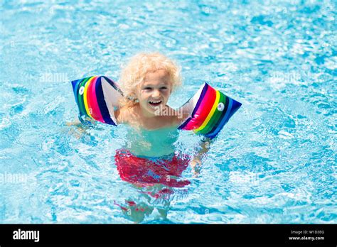 Child In Swimming Pool Wearing Colorful Inflatable Armbands Kids Learn
