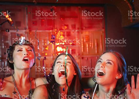 Three Women In A Nightclub Drinking And Laughing Stock Photo Download