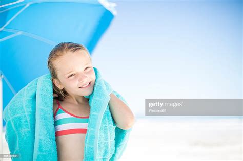 Smiling Girl On Beach Drying Off With A Beach Towel High Res Stock