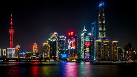 Shanghai Skyline Night Lights Reflecting In The Water Fondo De