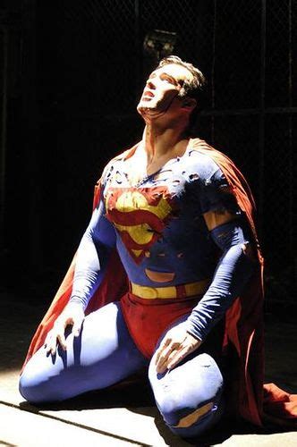 A Man Dressed As Superman Sitting On The Ground
