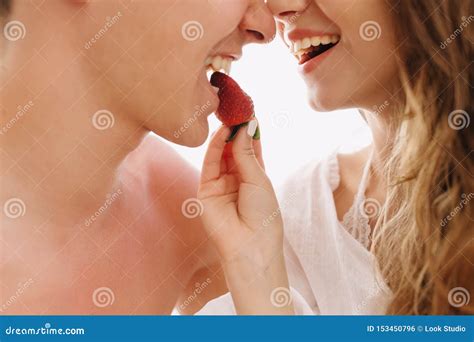 Close Up Portrait Of Beautiful Cheerful Couple In Love Eating Tasty Strawberry Together On White