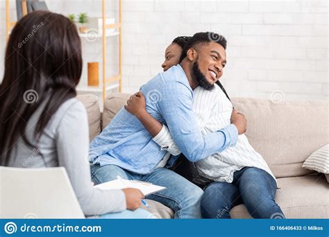 Married Couple Embracing After Successful Therapy At Counsellor`s
