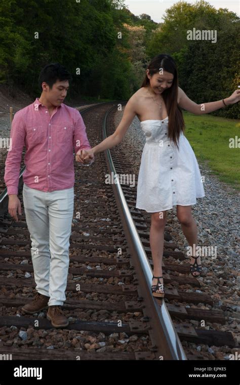 Romantic Asian Couple Playing Outside On Railroad Tracks Being