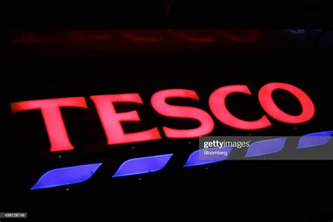 An Illuminated Tesco Sign Sits Above The Entrance To A Tesco Express