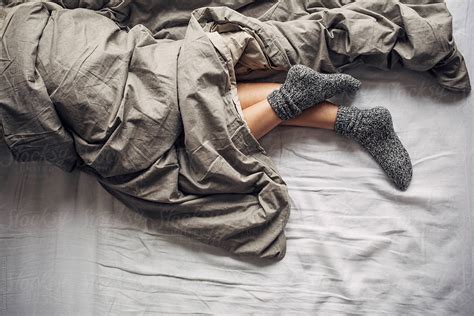 view woman wearing woollen socks sleeping in bed by stocksy contributor lumina stocksy