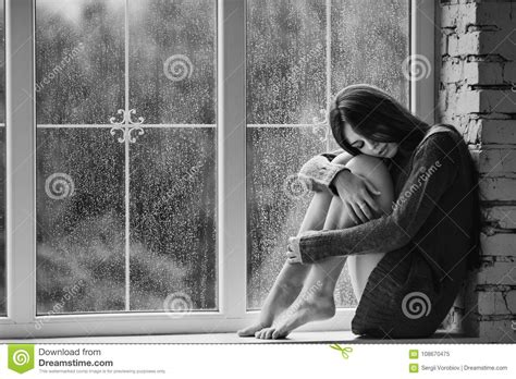 Beautiful Young Woman Sitting Alone Near Window With Rain Drops And