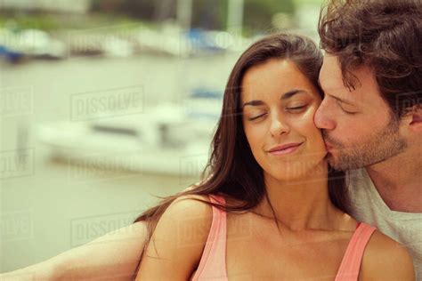 Boyfriend Kissing Girlfriend On Cheek Stock Photo Dissolve