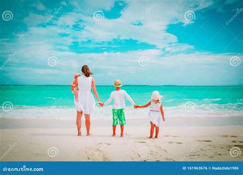 Madre Con Tres Hijos Caminando En La Playa Foto De Archivo Imagen De