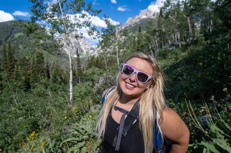 Happy Adorable Blonde Woman Hiker Wearing Sunglasses Smiles At The