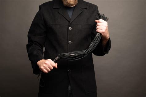 Premium Photo Male Dominant Holds A Leather Whip Flogger For Hard