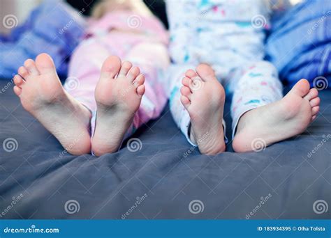 Childrens Feet On The Bedtwo Pairs Of Children S Feet On The Bed