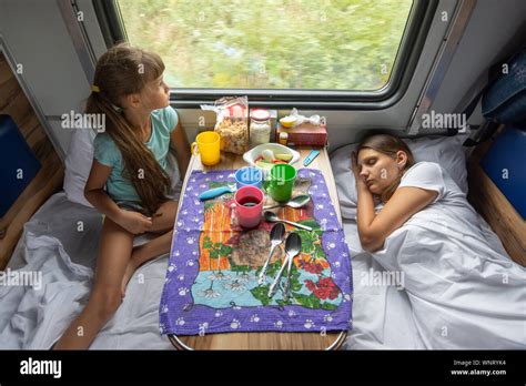 the situation on the train mom is sleeping daughter is looking out the window top view stock