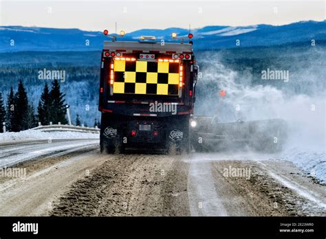 A Rear View Of A Department Of Highways Snow Plow Truck Plowing Snow
