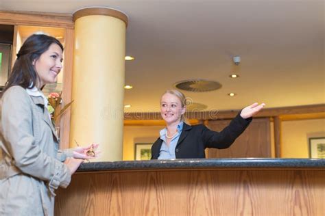 Smiling Receptionist Helping A Hotel Guest Stock Image Image Of