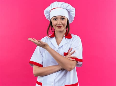 Erfreute Junge Köchin Die Kochuniform Trägt Zeigt Nach Oben Isoliert Auf Rosa Hintergrund