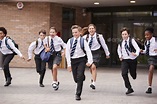 Group Of High School Students Wearing Uniform Running Out Of School ...