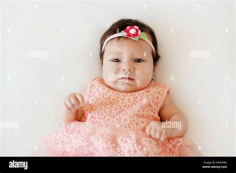Cute Baby Girl With Sad Face Lies On A White Blanket Stock Photo Alamy