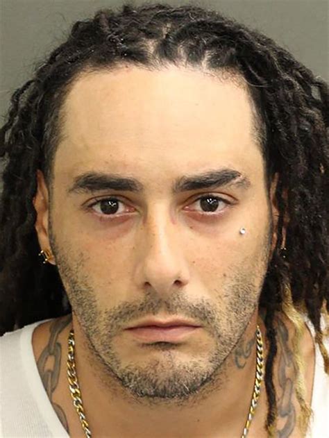 a man with long dreadlocks and piercings on his face is looking at the camera